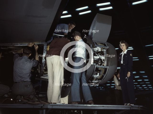 Installing an engine at the Consolidated Aircraft Corporation plant, Fort Worth, Texas, 1942. Creator: Howard Hollem.