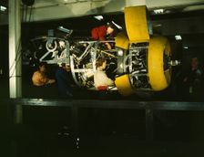 Installing one of the 4 motors on the transport plane at Willow Run, between 1941 and 1945. Creator: Howard Hollem