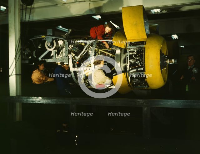 Installing one of the 4 motors on the transport plane at Willow Run, between 1941 and 1945. Creator: Howard Hollem.