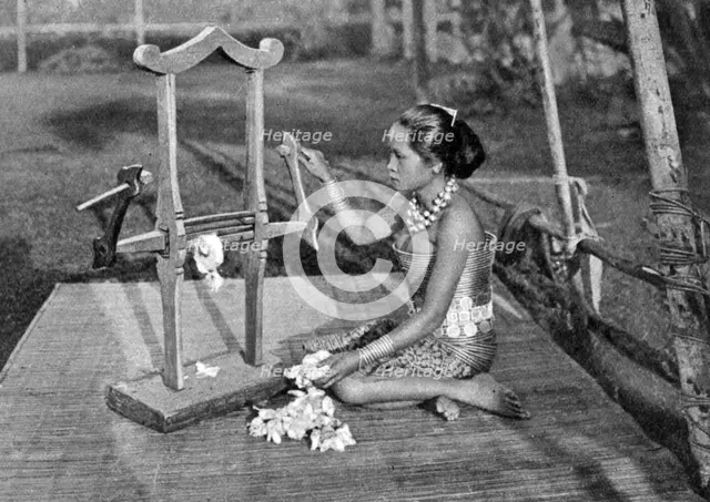 Iban woman making thread with a mangle, Borneo, 1922. Artist: Dr Charles Hose