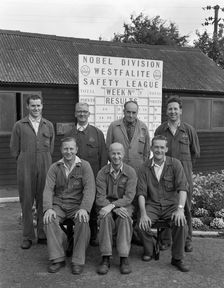 ICI powder works team in front of the Safety League board, Denaby Main, South Yorkshire, 1962. Creator: Michael Walters