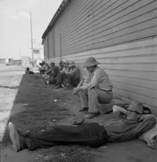 Idle men seated in shade on the other side of..., Tulelake, Siskiyou County, California, 1939. Creator: Dorothea Lange