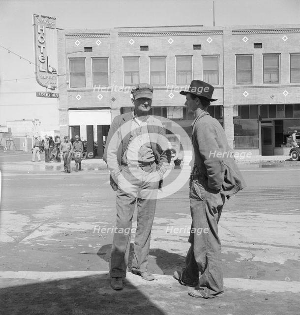 Idle pea pickers discuss prospects for work, Calipatria, Imperial Valley, California, 1939. Creator: Dorothea Lange.