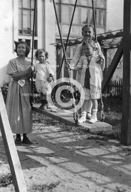 Irina, Yuliy and Vera Briner with nanny Katya in the courtyard of a house on Svetlanskaya St, 1923. Creator: Unknown.