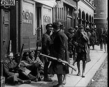 Irish Soldiers Sitting in the Street and Tending to Their Injuries from Fighting in Dublin, 1922. Creator: British Pathe Ltd