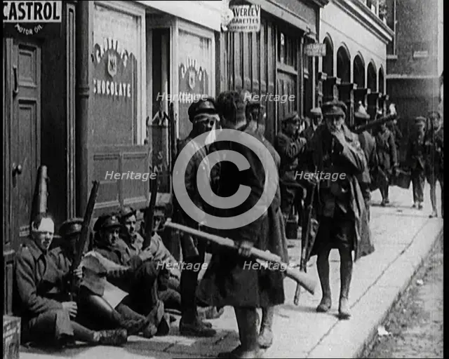 Irish Soldiers Sitting in the Street and Tending to Their Injuries from Fighting in Dublin, 1922. Creator: British Pathe Ltd.