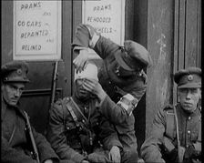 Irish Soldiers Sitting in the Street and Tending to Their Injuries from Fighting in Dublin, 1922. Creator: British Pathe Ltd