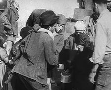 Italian Civilians Getting Assistance from American Soldiers in a Bomb-Damaged Italian Town, 1943-44. Creator: British Pathe Ltd