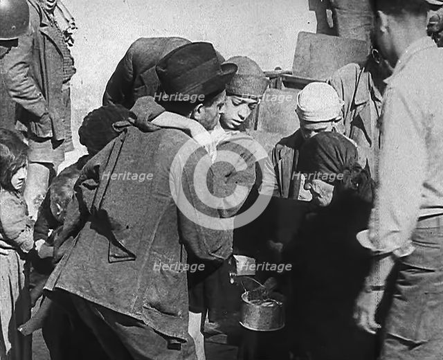 Italian Civilians Getting Assistance from American Soldiers in a Bomb-Damaged Italian Town, 1943-44. Creator: British Pathe Ltd.