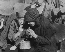 Italian Civilians Eating Food in a Bomb-Damaged Italian Town, 1943-1944. Creator: British Pathe Ltd