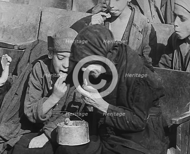 Italian Civilians Eating Food in a Bomb-Damaged Italian Town, 1943-1944. Creator: British Pathe Ltd.