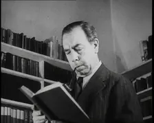 J.B. Priestly Reading and Smoking a Pipe, 1930s. Creator: British Pathe Ltd