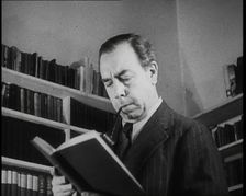 J.B. Priestly Reading and Smoking a Pipe, 1930s. Creator: British Pathe Ltd
