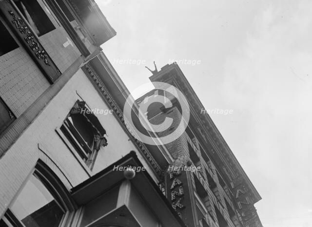 J. Reynolds, Performing Acrobatic And Balancing Acts On High Cornice Above 9th Street, N.W., 1917. Creator: Harris & Ewing.