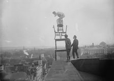 J. Reynolds, Performing Acrobatic And Balancing Acts On High Cornice Above 9th Street, N.W., 1917. Creator: Harris & Ewing
