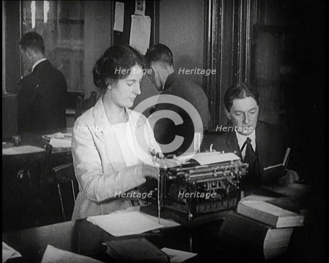 Journalists at Work Typing, Reading, and Making Notes. a Woman Is Typing What Is Being..., 1921. Creator: British Pathe Ltd.