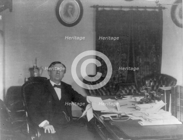 John Wanamaker, 1838-1922, three-quarter length portrait, seated, at desk, facing right, c1890. Creator: Frances Benjamin Johnston.