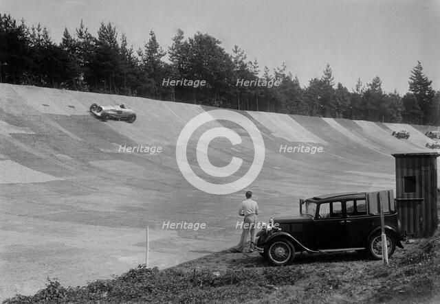 John Cobb's 24 litre Napier Railton on Byfleet Banking, BARC meeting, Brooklands, Surrey, 1933. Artist: Bill Brunell.