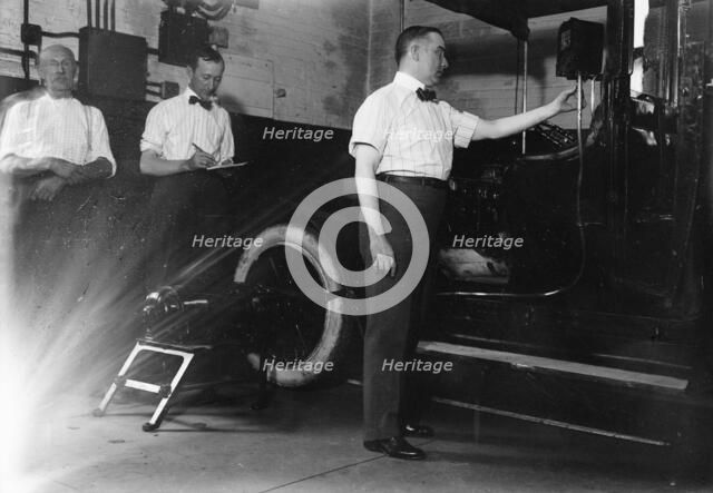 John Drennen inspecting meter, 1913. Creator: Bain News Service.