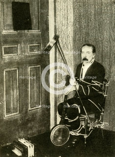 John Nevil Maskelyne performs a 'spirit cabinet illusion', c1910. Creator: Unknown.