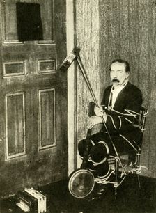 John Nevil Maskelyne performs a spirit cabinet illusion c1910. Creator: Unknown
