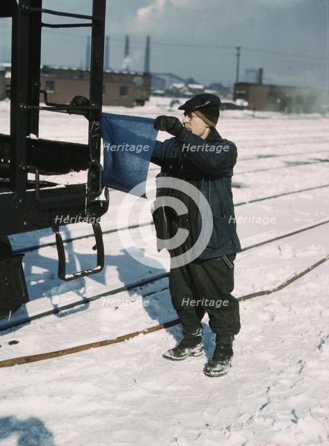 John Paulinski, car inspector, blue flagging a train for inspection, Corwith yard, Chicago, 1943. Creator: Jack Delano.