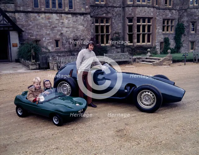 Jackie Stewart posing with a 1957 BRM. Artist: Unknown