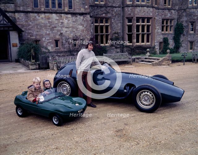 Jackie Stewart posing with a 1957 BRM. Artist: Unknown