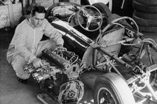 Jack Brabham inspecting the engine of a car