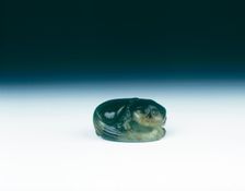 Jade cat sitting curled up scratching its ear with one eye closed, Yuan dynasty, China, 1279-1368