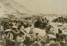 Japanese and Korean coolies removing supplies from wharf of Chemulpo, c1904. Creator: Robert Lee Dunn