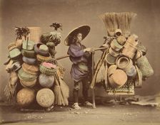 [Japanese Man Posing with Baskets, Brooms and Feather Dusters], 1870s. Creator: Unknown