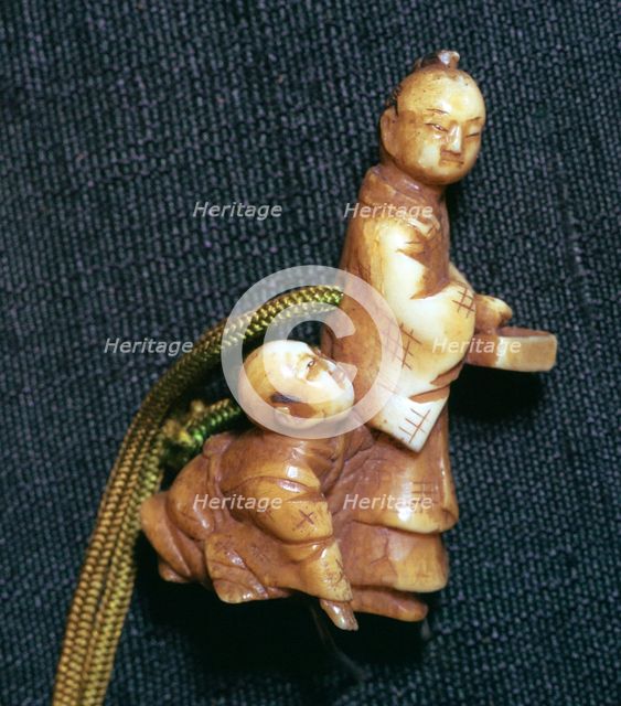 Japanese Netsuke of a man and boy at new year, 19th century. Artist: Unknown