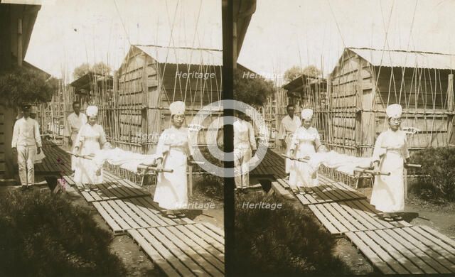 Japanese nurses carrying a patient on a stretcher, c1905. Creator: Underwood & Underwood.