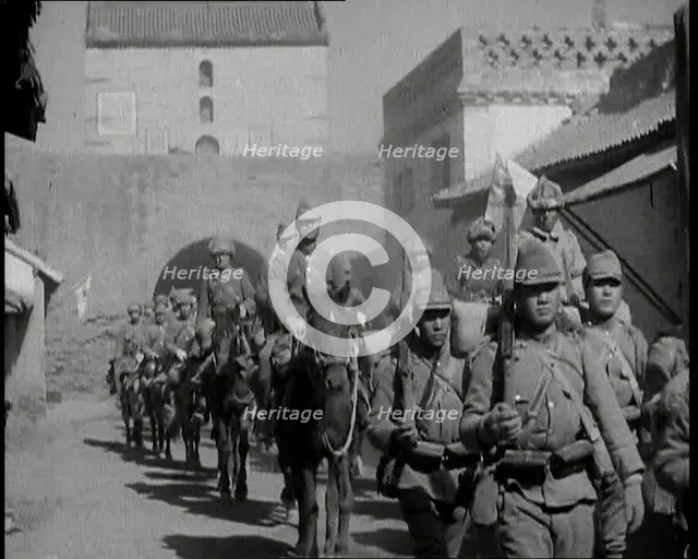 Japanese Soldiers Marching and Riding On Horseback Under an Arch and Through a Street..., 1937. Creator: British Pathe Ltd.