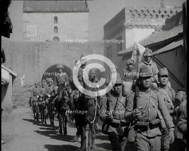 Japanese Soldiers Marching and Riding On Horseback Under an Arch and Through a Street..., 1937. Creator: British Pathe Ltd.