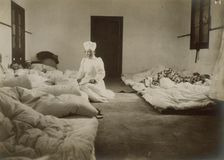 Japanese Red Cross nurses at Chemulpo attending Russian soldiers wounded in battle of Feb. 9, c1904. Creator: Robert Lee Dunn