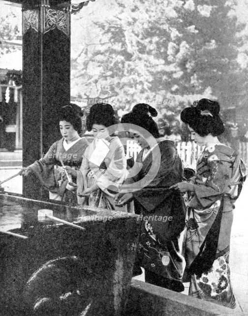 Japanese women washing their hands prior to entering a temple, 1936.Artist: Sport & General