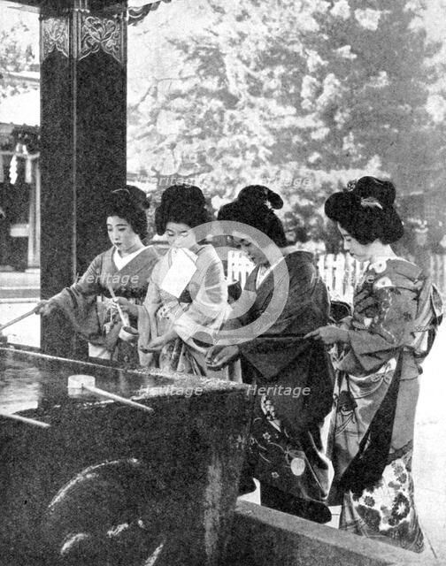 Japanese women washing their hands prior to entering a temple, 1936.Artist: Sport & General