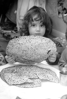 Jewish child holding Passover matzot, Edgware, London, 29 March 1991. Creator: John Nathan