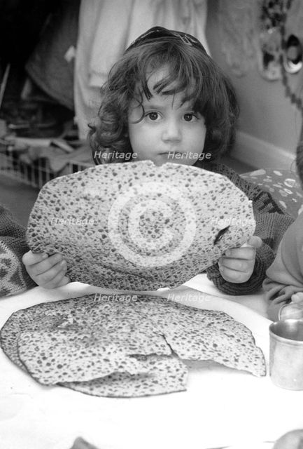Jewish child holding Passover matzot, Edgware, London, 29 March 1991. Creator: John Nathan.