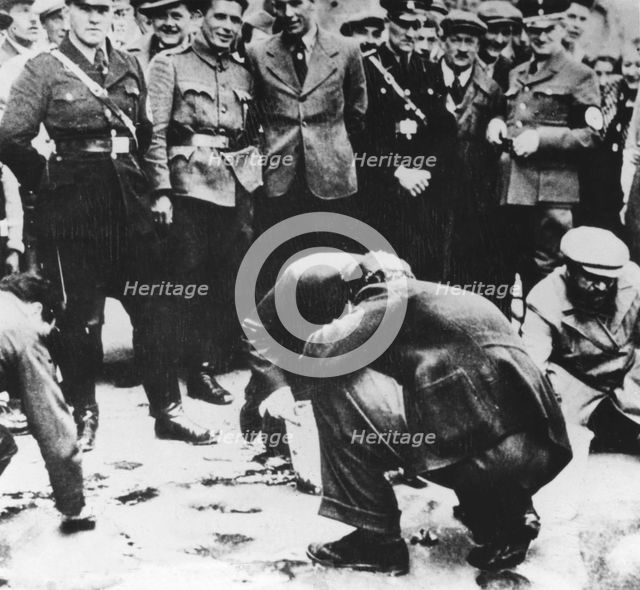 Jews are made to clean the streets of Vienna after the Anschluss, 1938. Artist: Unknown