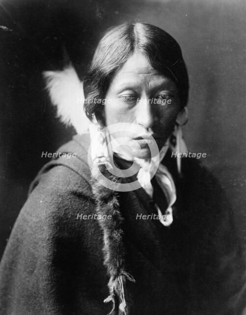 Jicarilla man, head-and-shoulders portrait, facing slightly right, with fur wrapped braids..., c1905 Creator: Edward Sheriff Curtis.