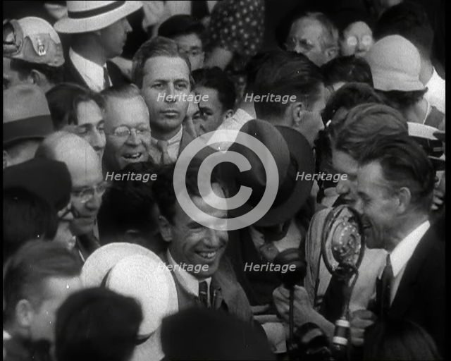 Jim Mollison Walking Surrounded by a Large Crowd, 1930s. Creator: British Pathe Ltd.