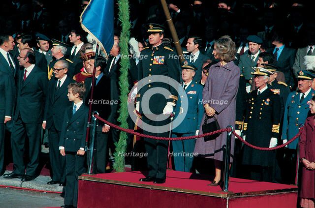 Juan Carlos I, King of Spain, with Queen Sofia and Prince Felipe, presiding over a military parad…