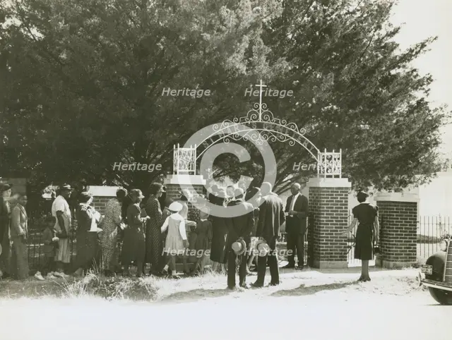 On All Saints' Day at New Roads, La. African Americans lined up at gates to enter cemetry, 1938. Creators: Farm Security Administration, Russell Lee.