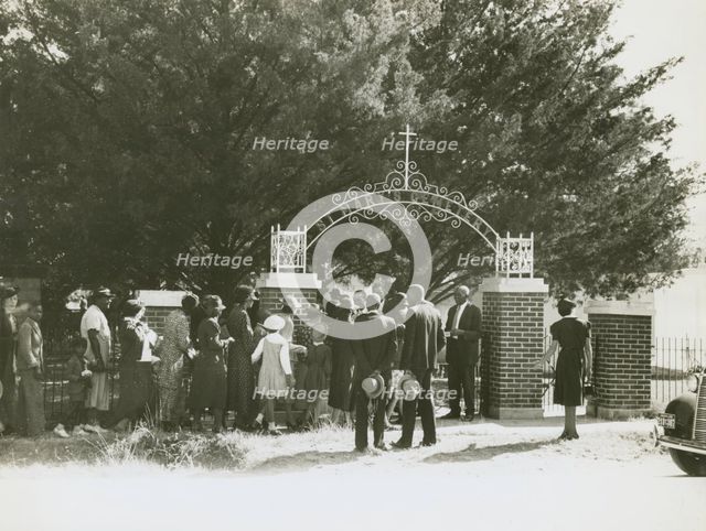 On All Saints' Day at New Roads, La. African Americans lined up at gates to enter cemetry, 1938. Creators: Farm Security Administration, Russell Lee.
