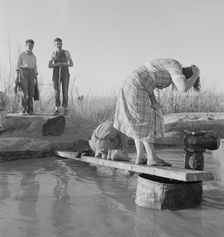 Oklahoma migratory workers washing in a hot spring in the desert, Imperial Valley, California, 1937. Creator: Dorothea Lange