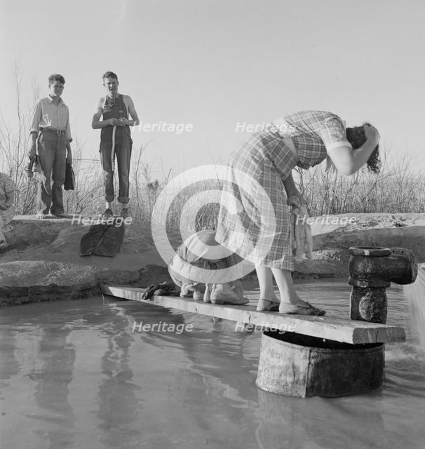 Oklahoma migratory workers washing in a hot spring in the desert, Imperial Valley, California, 1937. Creator: Dorothea Lange.