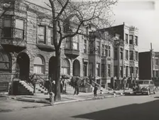 Old brown stonehouses now occupied by Negroes in Chicago, Illinois, April 1941. Creators: Farm Security Administration, Russell Lee